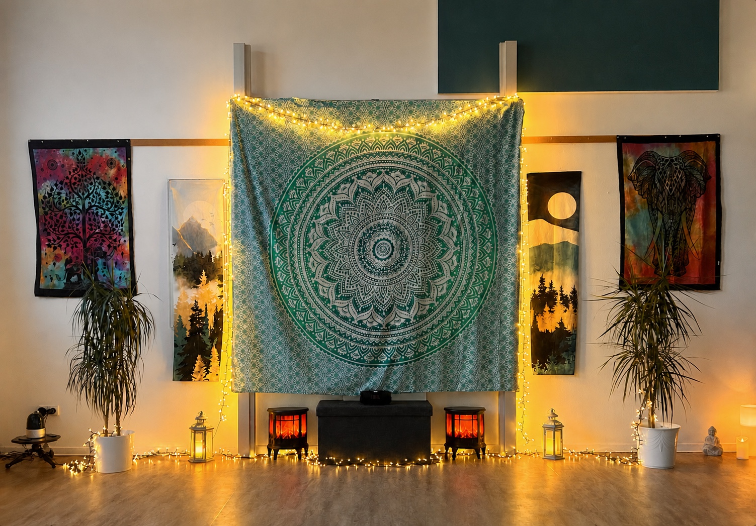 Frontaler Blick auf den warm beleuchteten Yogaraum mit großem Mandala-Tuch